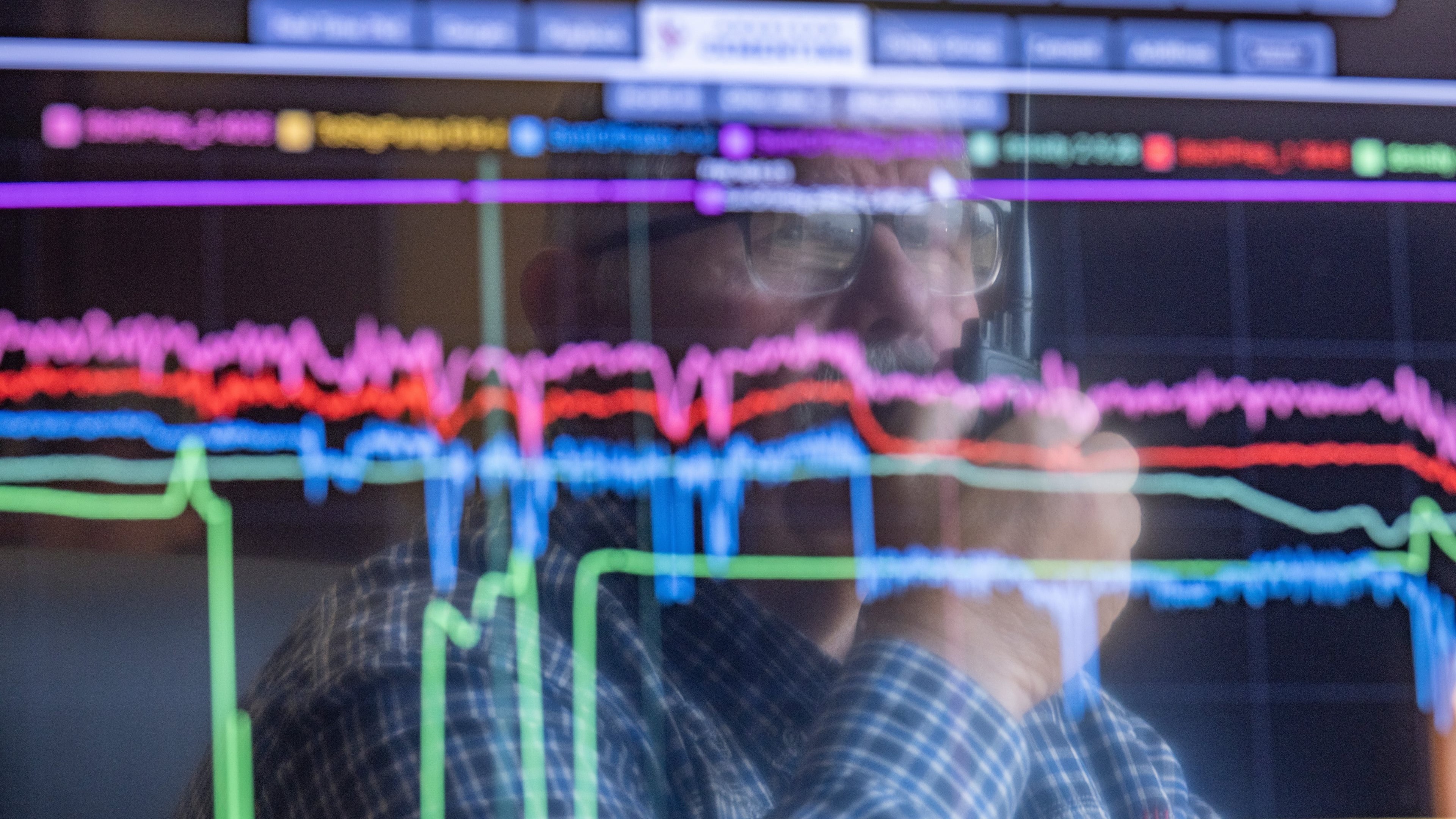 A man reflected in data on a computer screen